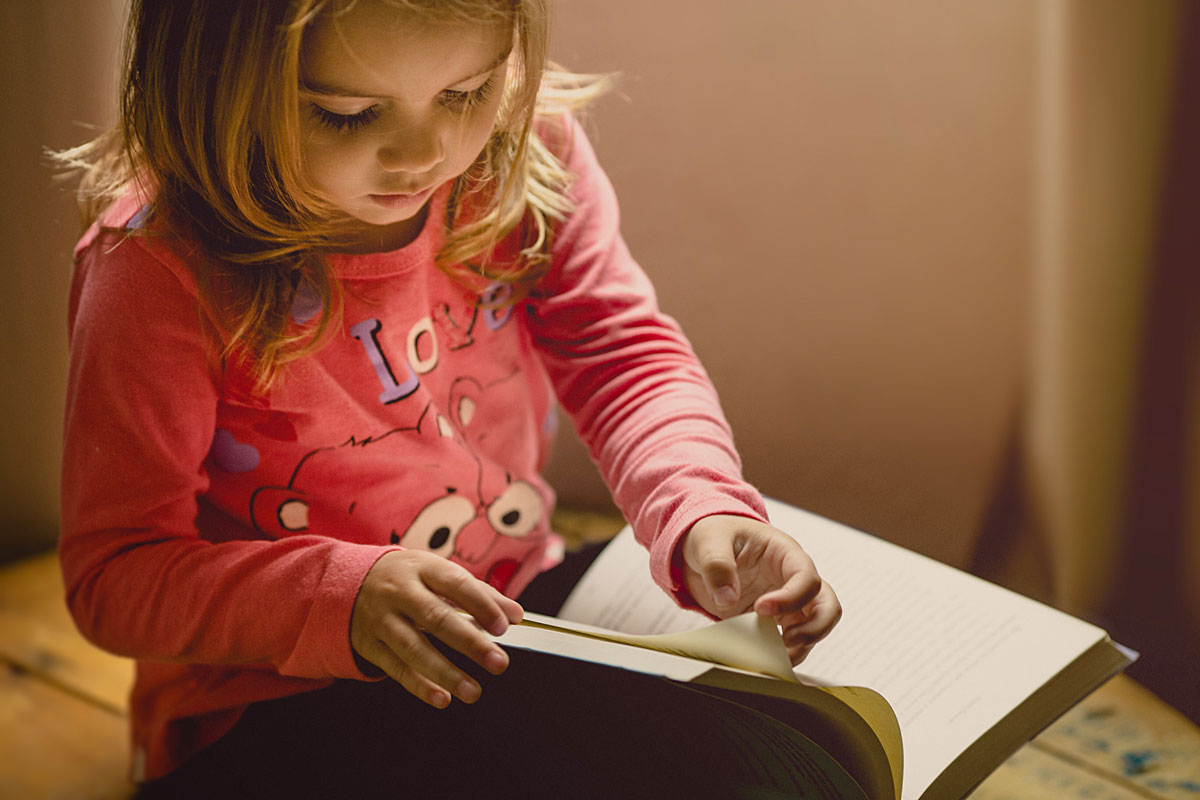 Female child sitting reading a book